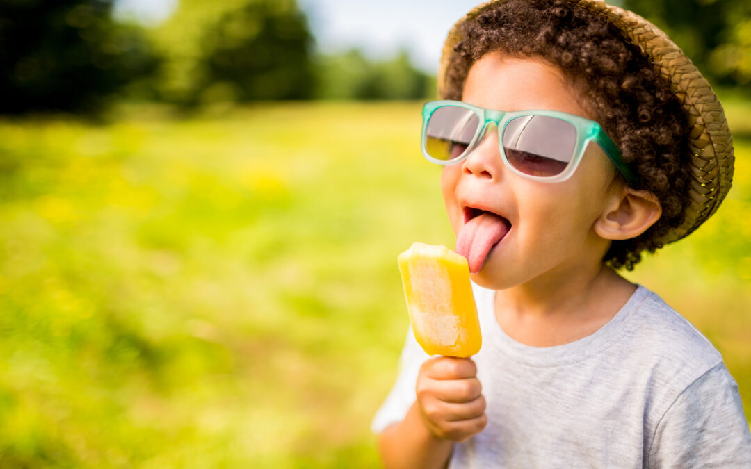 A young boy enjoys an ice block in the summer sun - heat and cool heat pumps will keep you cool this summer