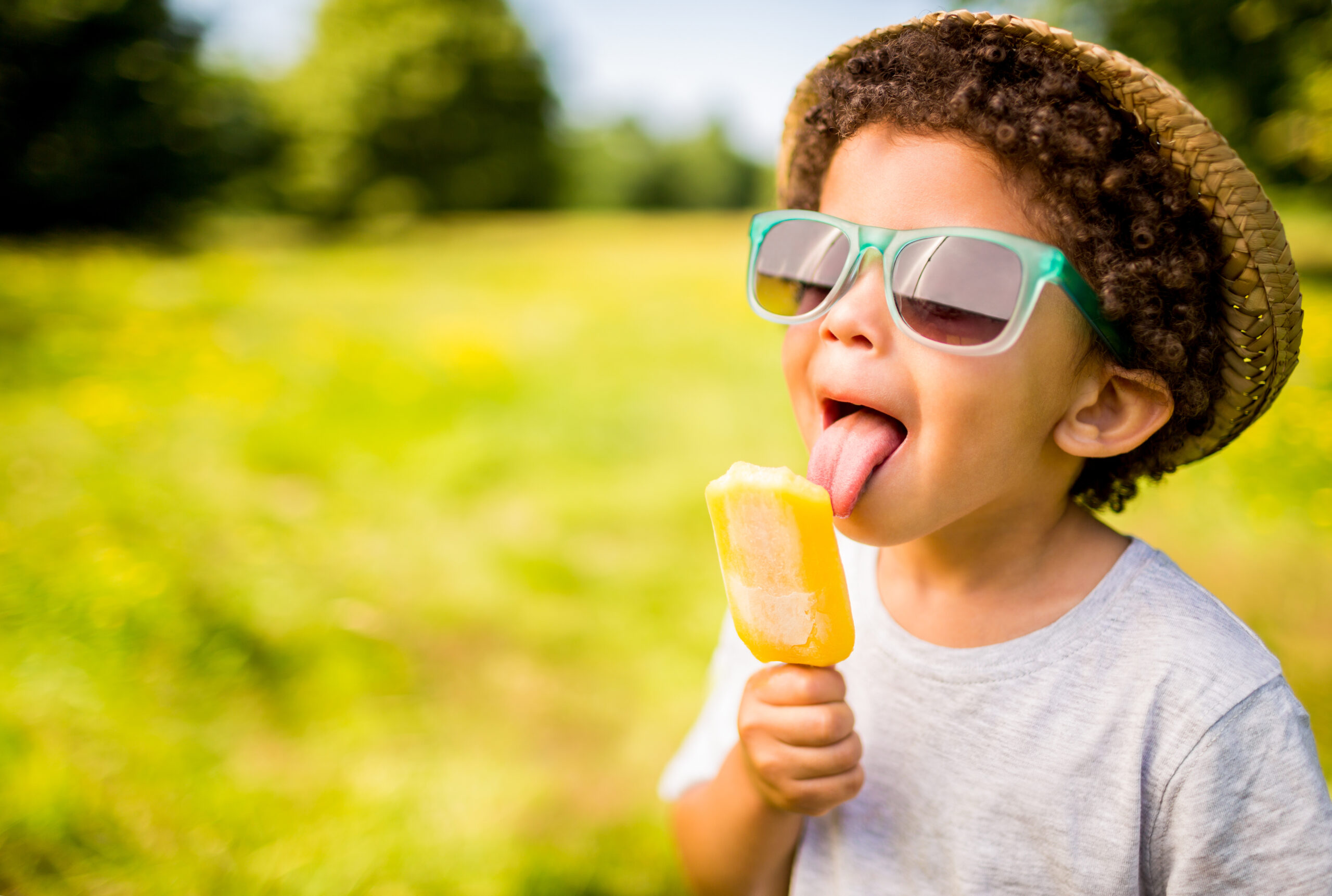 A young boy enjoys an ice block in the summer sun - heat and cool heat pumps will keep you cool this summer
